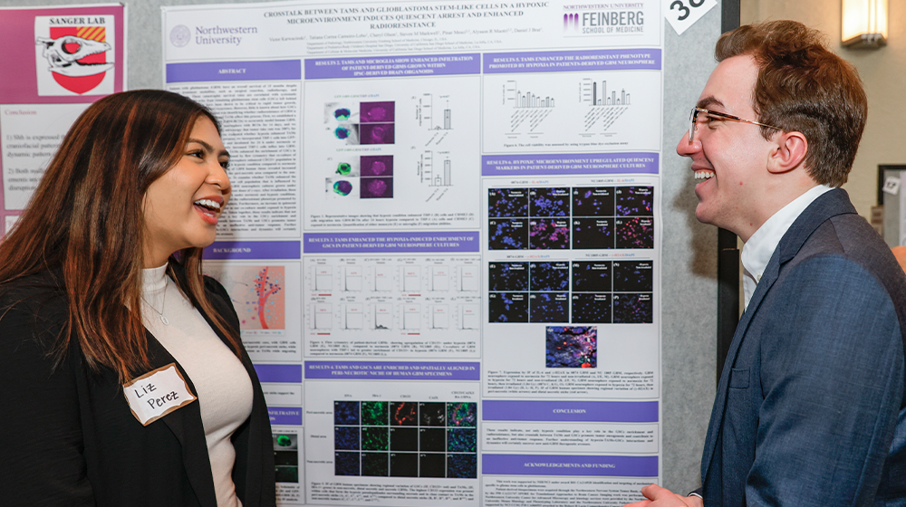 Undergraduate students stand in front of poster at USRE event.